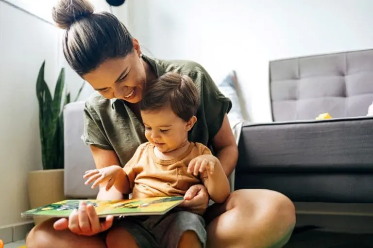A mom reading to her child in the living room.